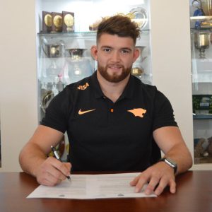Firmando su primer contrato como profesional