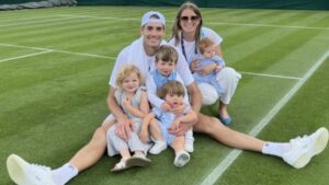 John Isner junto a su esposa y sus cuatro hijos sobre una cancha de tenis.